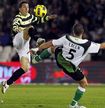 El delantero del Hércules, Cristian Hidalgo, disputa el balón ante el centrocampista del Racing de Santander, Mehdi Lacen.
