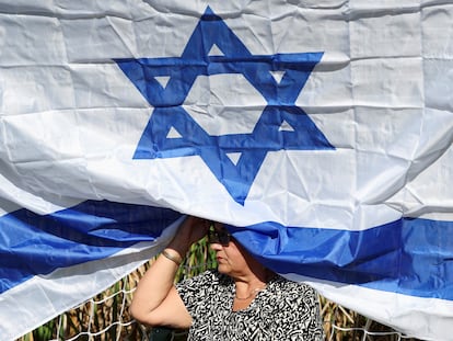 Una mujer sentada debajo de una bandera de Israel, durante una ceremonia en memoria de las víctimas del ataque de Hamás, el 16 de noviembre en el kibutz Gezer.