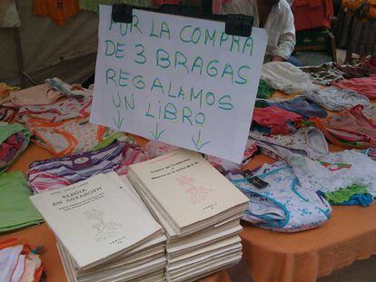 Cartel en un mercadillo madrileño que oferta un libro de regalo por la compra de tres bragas.