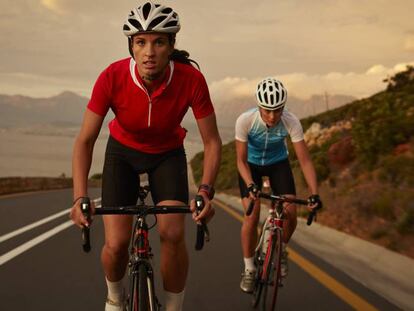 Dos ciclistas subiendo un puerto en carretera.