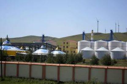 Imagen de unos silos de grano junto a las construcciones típicas de la Mongolia Interior (China) con molinos de viento en el distrito de Hulunber, conocido como "La perla de las praderas", que ocupan 253.000 kilómetros, una octava parte del territorio de México.