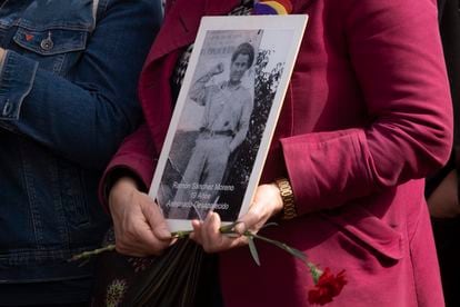 Una mujer porta la imagen de un desaparecido.