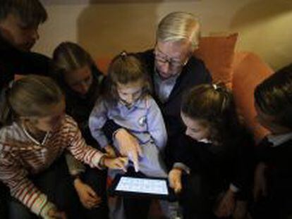 Un interno de Sanitas Residencial maneja un iPad con la &#039;app&#039; Pupitre con sus nietos.