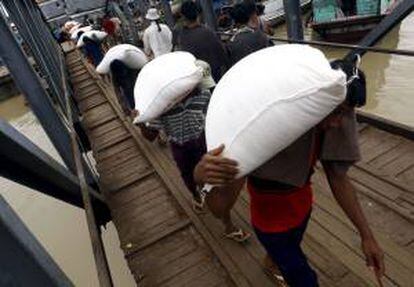 Trabajadores birmanos descargan sacos de arroz de un barco en el muelle de Rangún, en Birmania. EFE/Archivo