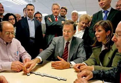 El presidente del PP Mariano Rajoy junto a la candidata del PP catalán a la Generalitat, Alicia Sánchez- Camacho, juega al dominó durante su visita esta mañana a una residencia de gente mayor de Cerdanyola del Vallès.