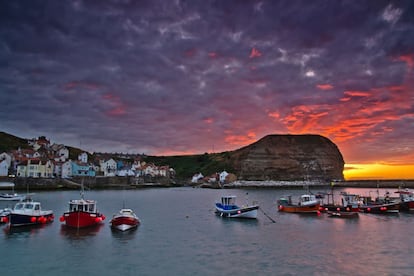 Este pueblo del noreste inglés no ha cambiado apenas desde los años 50. Cobijado entre dos escarpes, este antiguo puerto, donde trabajó el mítico capitán James Cook, puede ser un lugar despiadado en invierno y de difícil acceso. Sin embargo, muchos visitantes se acercan cuando el tiempo mejora para dar un paseo por la loma de sus acantilados y dedicar unas horas a buscar fósiles de amonites, por cuya abundancia es conocida la zona.