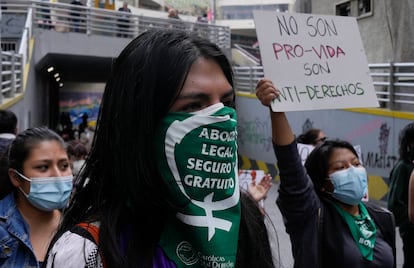 A woman wears a protective face mask with a message that reads in Spanish; "Legal abortion safe and free" during an abortion rights demonstration, outside the offices of the Bolivian Episcopal Conference, in La Paz, Bolivia, Friday, Oct. 29, 2021. The case of an 11-year-old girl raped and five months pregnant, who is in a reception center of the Catholic Church, has rekindled the debate on abortion in Bolivia.  (AP Photo / Juan Karita)