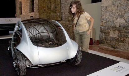 Una joven observa, en el Palacio Villasuso de Vitoria, el prototipo de coche eléctrico proyectado por la empresa Hiriko.