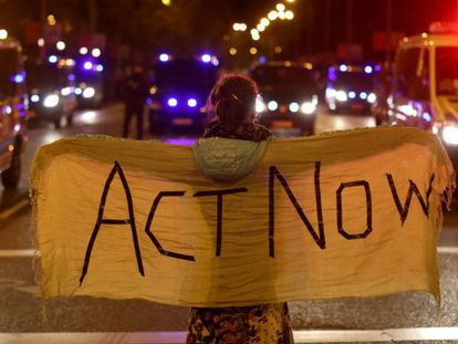 Una manifestante, con una pancarta con el lema