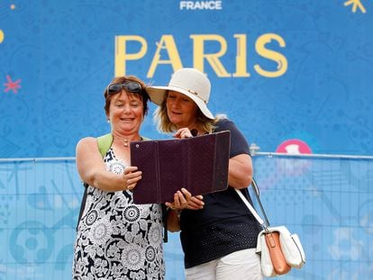 Unas turistas se toman un selfi frente a un cartel publicitario de París en el verano de 2016 durante la final de la Eurocopa.