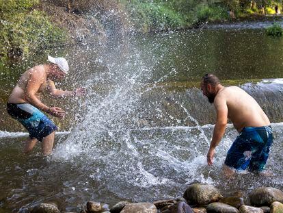 Dos hombres se refrescan en el río Iregua en Logroño, este sábado.