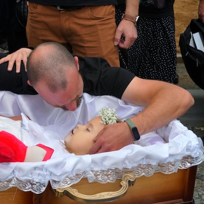 Artem Dmitriev gives the last salute to his daughter Liza, 4-year-old girl killed by Russian attack, in Vinnytsia, Ukraine, Sunday, July 17, 2022. Wearing a blue denim jacket with flowers, Liza was among 23 people killed, including two boys aged 7 and 8, in Thursday's missile strike in Vinnytsia. Her mother, Iryna Dmytrieva, was among the scores injured. (AP Photo/Efrem Lukatsky)
