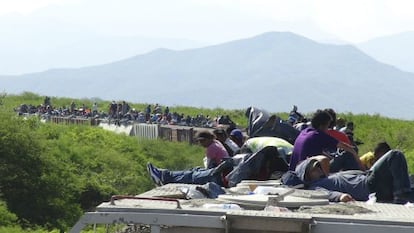 Migrantes viajan encima del tren conocido como La Bestia en Ixtepec (M&eacute;xico), en junio de 2014.