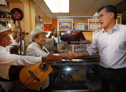 Mitt Romney saluda a dos m&uacute;sicos en un restaurante en Hialeah (Florida).