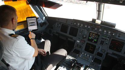 Un piloto de Iberia revisa el libro de ruta en la cabina del avi&oacute;n. / Pablo Monge