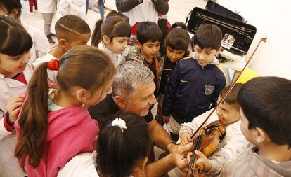Darko Milowic, músico de la Filarmónica de Luxembrugo, comparte su violín con los alumnos de una escuela de la Villa 31 de Buenos Aires.