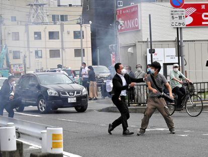 A police officer detains a man believed to have shot former Japanese Prime Minister Shinzo Abe in Nara, Japan.