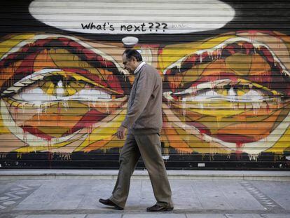 Un hombre pasea ante un grafiti en Grecia que pregunta: "Qué vendrá después?".
