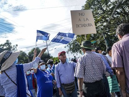 Un manifestante sostiene un cartel que dice "No a la dictadura" durante una protesta en El Salvador.