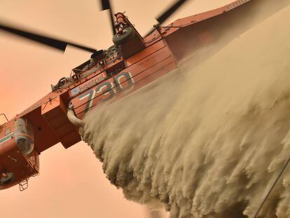 Un helicóptero arroja retardante de fuego para proteger una propiedad en Balmoral (Sydney).