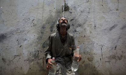 Un hombre se refresca en una fuente de Karachi (Pakistán) para paliar los efectos de las altas temperaturas.