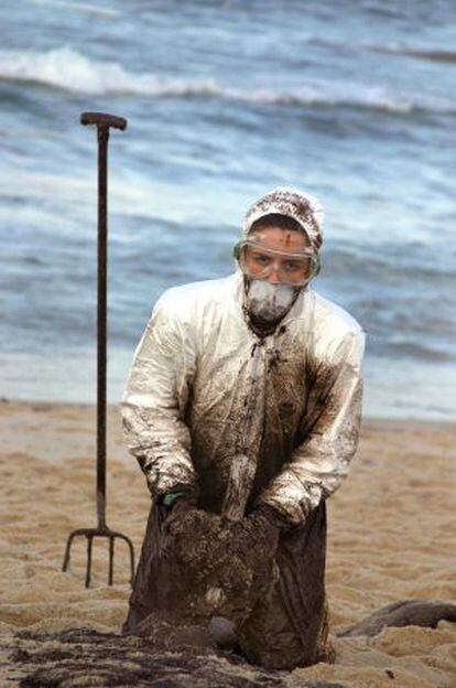 Una voluntaria recoge chapapote en Lira (A Coruña) en 2002.