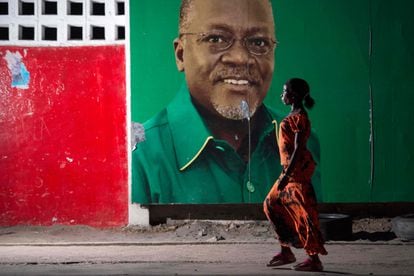 Una mujer camina delante de un mural en una calle de Dar es Salam, Tanzania, con el retrato del recientemente fallecido presidente del país, John Magufuli, en octubre de 2015, cuando este ganó las elecciones por primera vez.