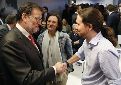 El presidente del Gobierno en funciones, Mariano Rajoy (i), saluda al líder de Podemos, Pablo Iglesias (d), en presencia de la diputada de Podemos, Carolina Bescansa (c), durante el acto de entrega de los II Premios Efe Cultura que se ha celebrado en la sede de la Agencia Efe.