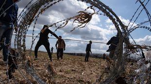 Migrantes intentan saltar la valla fronteriza en el paso turco de Pazarkule border crossing with Greece's Kastanies.