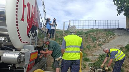 Operarios municipales de Karrantza (Bizkaia) extraen agua de un camión cisterna para incorporarla a la red de suministro.