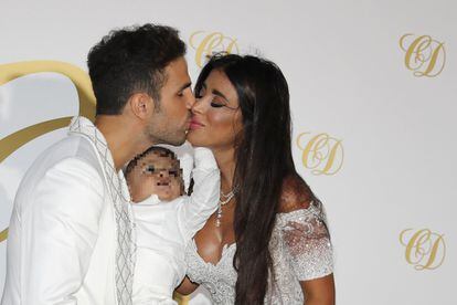 Cesc Fábregas besa a su mujer, Daniella Semaan, con el hijo menor de ambos en brazos.