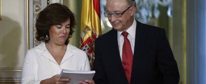 La vicepresidenta del Gobierno, Soraya Sáenz de Santamaría, y el ministro de Hacienda, Cristóbal Montoro, sostienen el informe sobre financiación autonómica.