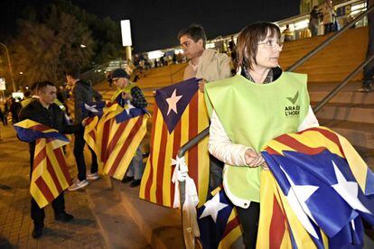 Reparto de banderas esteladas a las puertas del Camp Nou en las horas previas al partido.