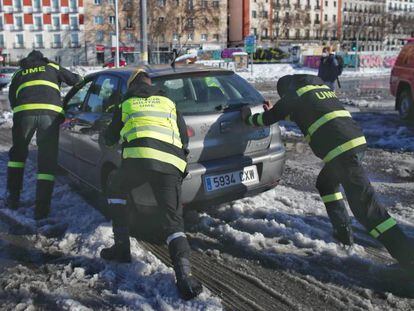 Militares de la UME ayudan a un coche a salir de la nieve en la Estación Puerta de Atocha, en Madrid (España), a 11 de enero de 2020. 