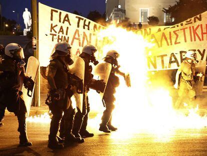 Policía antidisturbios entre las llamas de las bombas de gasolina lanzadas por un pequeño grupo de manifestantes anti-sistema frente al Parlamento en Atenas.