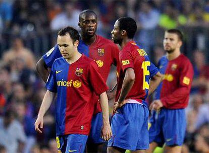 Iniesta abandona el campo tras el partido, ante Touré, Keita y, al fondo, Piqué.