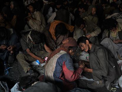 Sin apenas espacio para moverse, cientos de hombres con sumen droga debajo del puente de Pul-e-Sukhta de Kabul (Afganistán).