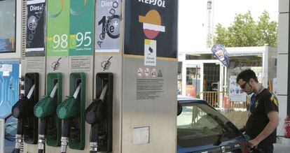 Un joven pone gasolina a su coche en un surtidor Repsol.