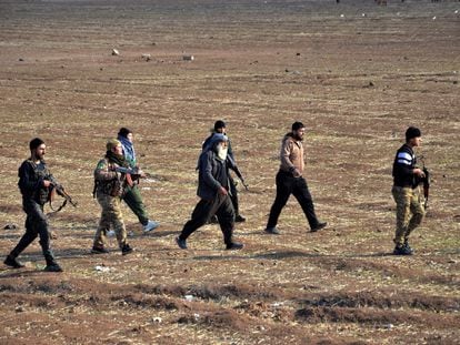 Combatientes de las Fuerzas Democráticas Sirias escoltan a dos miembros del ISIS hacia la prisión de Ghwayran, en Hasaka, este miércoles.
