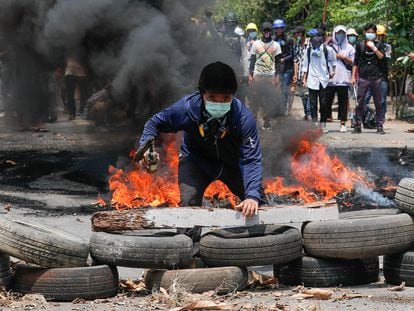 Un activista junto a una barricada improvisada por los manifestantes, este sábado en Yangón.