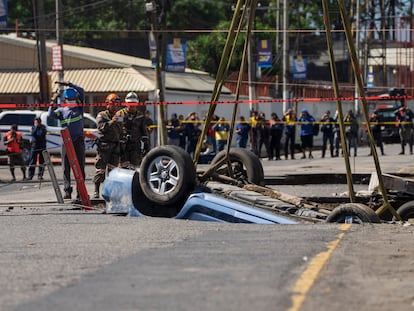 Un vehículo es rescatado del socavón en Villa Nueva, Guatemala, el 25 de septiembre de 2022.