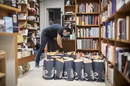 Un traballador de la llibreria Laie, organitzant bosses de llibres per enviar, aquest matí.