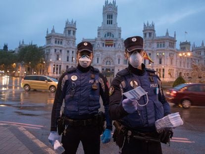 Policías Municipales ofrecen mascarillas en la plaza de la Cibeles.