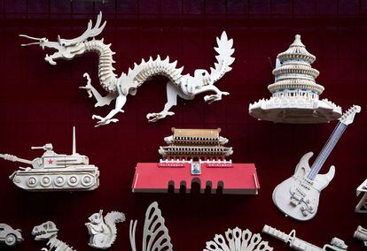 Un dragón, entre varias maquetas de madera, en un comercio de Pekín.