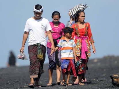 Una familia balinesa pasea por la playa en la localidad de Giangar, en Bali. el 12 de mayo de 2019. 