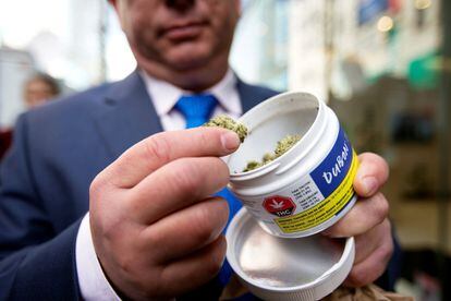 Un hombre muestra su compra adquirida en la tienda Quebec Cannabis Society de Montreal (Canadá).