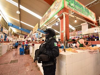 Un policía resguarda puestos de pollo en Chilpancingo (Guerrero), luego del asesinato de ocho comerciantes en junio de 2022.
