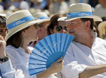 Rajoy conversa con su mujer, Elvira Fernández, durante el mitin celebrado ayer en Zaragoza.