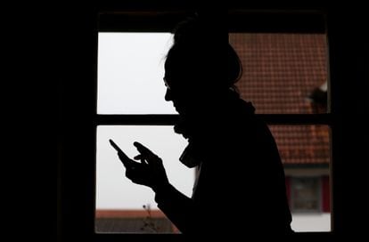 A woman uses her mobile phone at home.