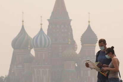 Dos turistas en la plaza Roja de Moscú se protegen con mascarilla del humo que afecta a la capital rusa.